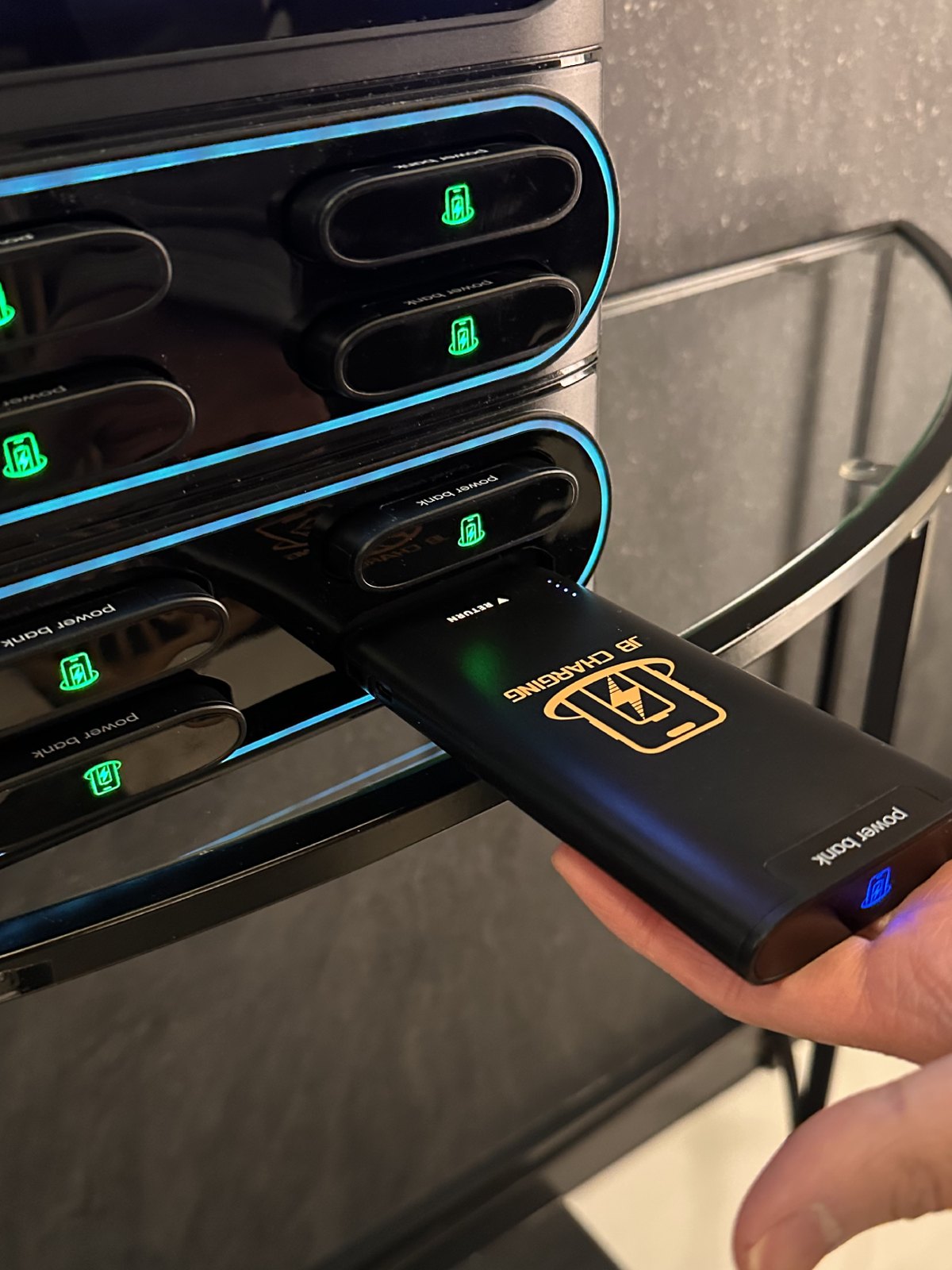 Hand putting a power bank back into a station slot